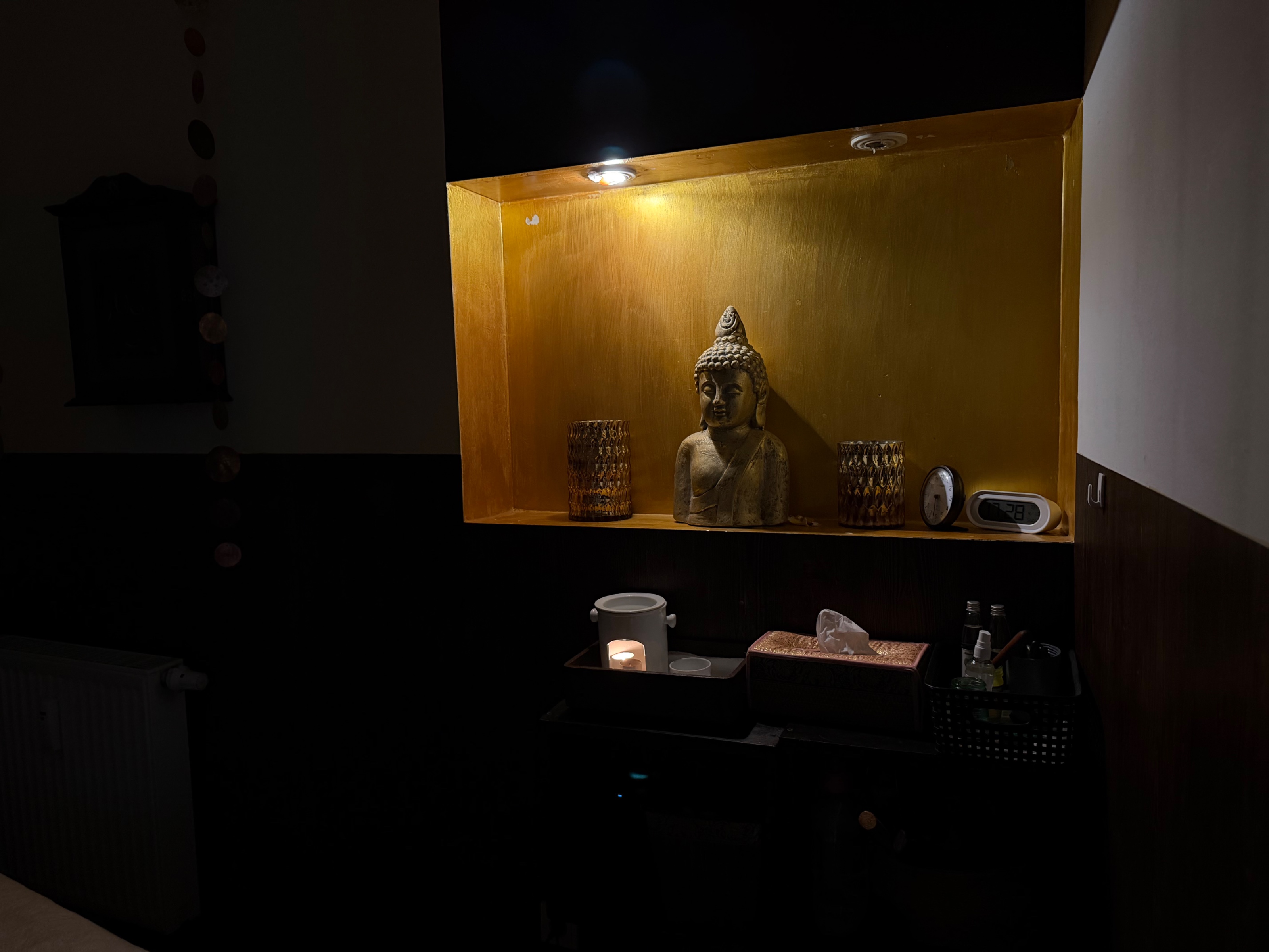 Goldene Buddha-Nische mit warmem Kerzenlicht bei Niewthong